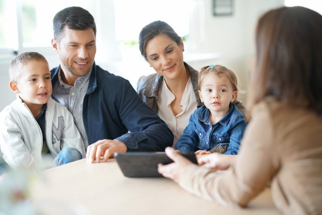 Family meeting financial advisor with an iPad over a table.