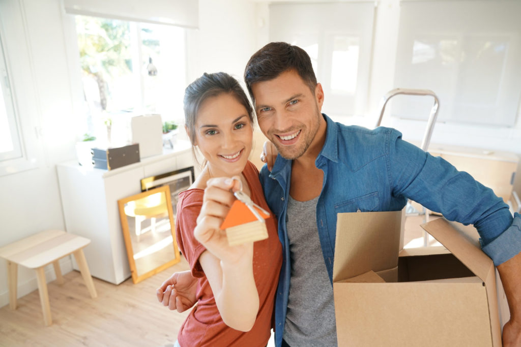 Happy couple showing keys of new home
