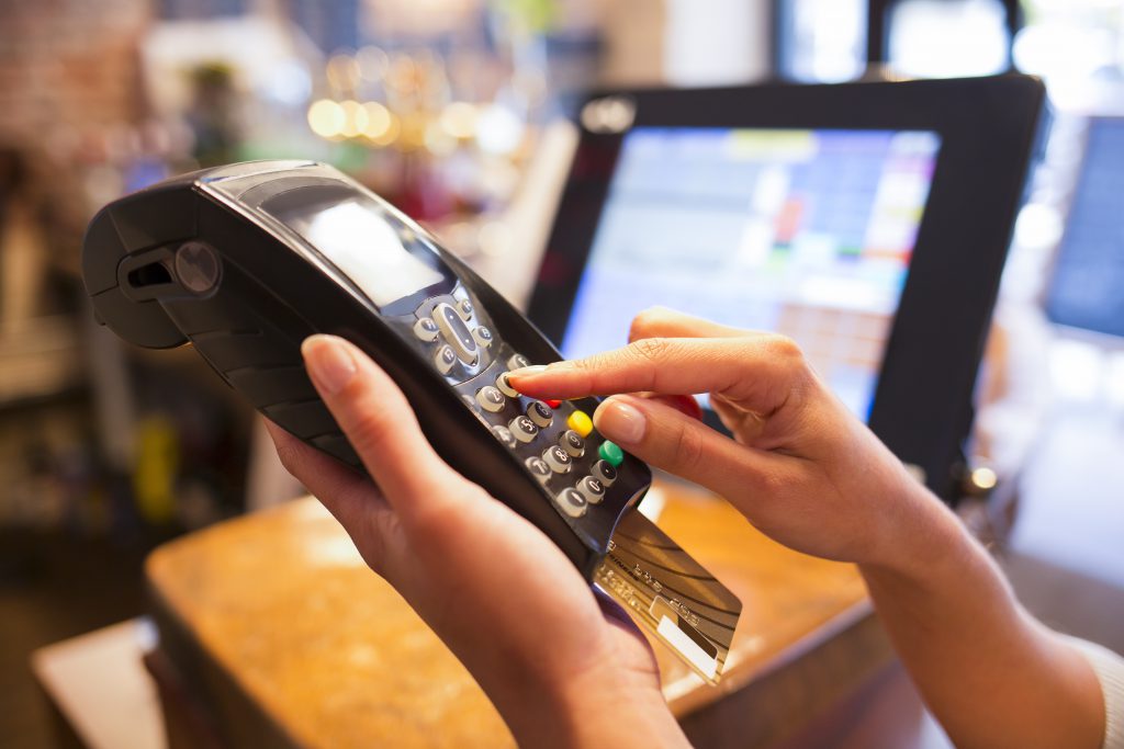 Woman using electronic reader to read credit and debit cards for her business.